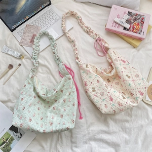 Detail of cartoon embossed canvas tote bag with ruffled cloud straps and drawstring closure