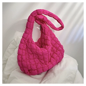 Close-up of rose pink quilted cloud bag with padded texture and metallic zipper detail