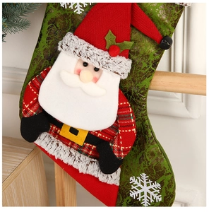 Détail d'un personnage de Père Noël 3D sur une chaussette de Noël rouge et verte avec flocons