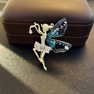 Elegant gold ballerina brooch with sparkling rhinestones and translucent wings on leather box