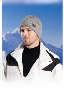 Winter outdoor grey knit beanie worn by model against a scenic snow mountain backdrop