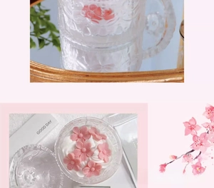 Macro view of peach blossom cake scented candle in embossed glass jar with pink wax petals