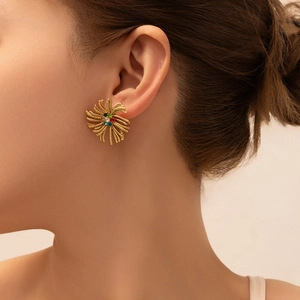 Detail view of a vintage gold-plated sunflower stud earring with colorful crystals on model