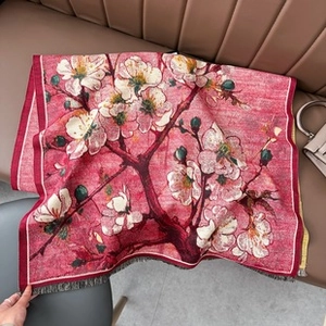 Detail shot of a cashmere-like scarf featuring red base and white floral oil painting patterns