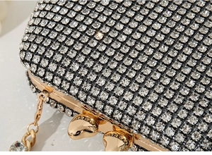 Macro shot of sparkling rhinestone evening bag with heart-shaped golden metal clasps