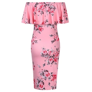 Détail d'une robe de maternité rose à fleurs avec col bardot et motif de roses