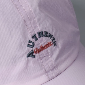 Detailed close-up of high-quality dual-color embroidery on a purple quick-dry cap