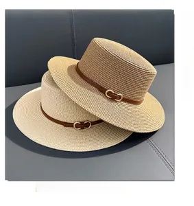 Detailed texture of flat top straw boater hats with brown leather bands and gold buckles