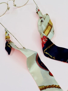 Detail of gold round glasses with a vintage floral silk ribbon decorative lanyard