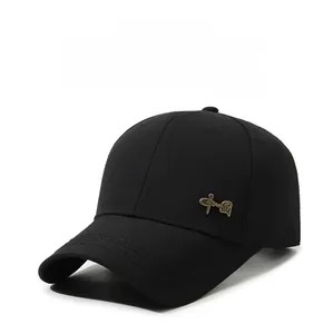 Detail of black cotton baseball cap featuring a vintage gold Chinese metal emblem