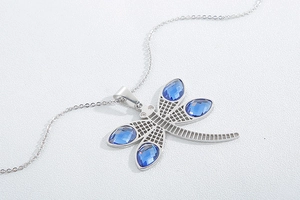 Detailed view of dragonfly pendant with blue crystals and silver stainless steel chain