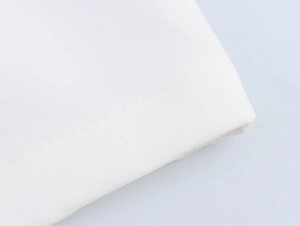 Detailed close-up of white fabric texture and premium stitching on a sleeveless vest set