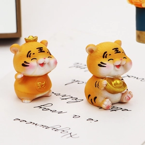 Close-up of cute resin tiger figurines with gold fortune symbols for car decor