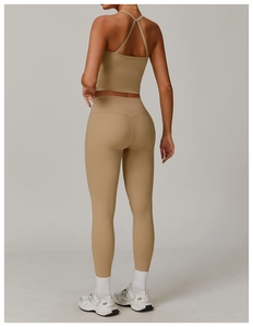 Rear view of high waist khaki yoga pants and cross strap sports bra set on fit model
