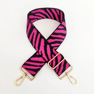 Detail of pink and black zebra print bag strap with golden metal swivel hooks