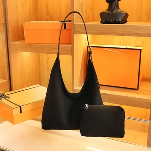 Black cat-themed shoulder bag with matching pouch shown on display with orange gift boxes