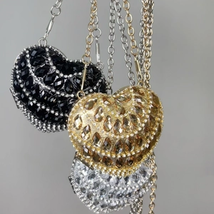 Three heart-shaped rhinestone crossbody bags in black, gold and silver finishes