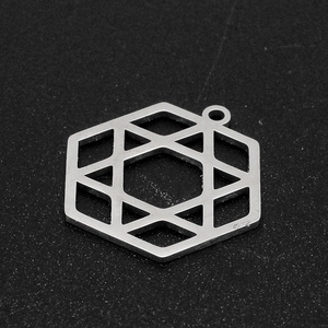 Macro detail of a silver stainless steel hexagonal pendant with geometric star cutout