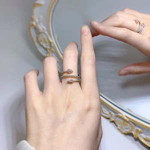Detail of 925 silver snake ring with sparkling pink stones on a model's hand