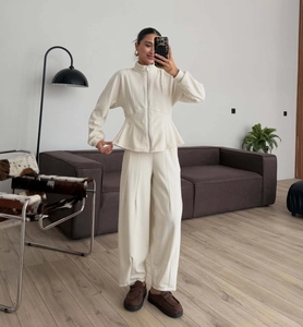 Detailed texture of ribbed knit fabric on cream-white zip-up hoodie and high-waist pants