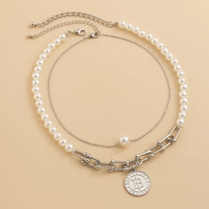 Detail of double-layer necklace with pearls, metal U-links, and a silver coin 'B' pendant