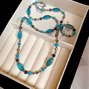 Collier rétro perles turquoise bleues et verre vert dans un écrin en velours crème