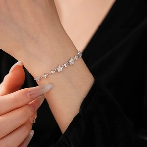 Close-up of elegant silver star bracelet with sparkling zircon on woman's wrist