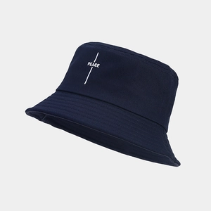 Detail of peace embroidery and reinforced stitching on a navy cotton bucket hat