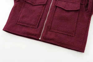 Détail de la veste bordeaux texturée avec fermeture éclair métallique et poches plaquées