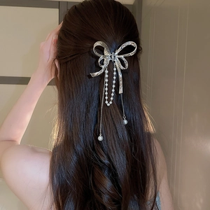 Elegant silver butterfly hair claw with flowing pearl tassels on model back view