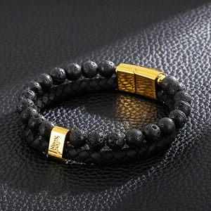 Detail of men's leather bracelet with black lava beads and gold magnetic clasp