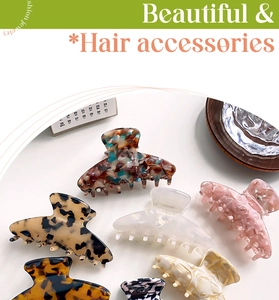 Close-up of assorted tortoise shell and marble acetate hair claws on a wooden tray