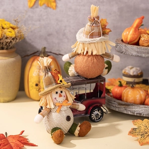 Detail of Thanksgiving harvest scarecrow dolls on vintage toy car with pumpkins and maple leaves