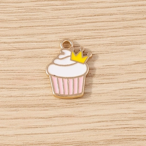 Detailed view of crown cupcake pendant charm with pink and white enamel on wood