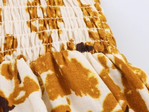 Détail du smock élastique sur une robe bohème crème à imprimé abstrait marron
