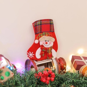 Red fabric Christmas stocking with plaid cuff featuring a 3D snowman and snowflake decor