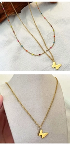 Close-up of gold butterfly pendant necklace with colorful beads and double-layered chains