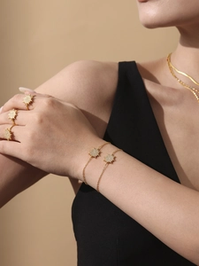 Close-up of gold stainless steel jewelry set with sparkling starburst zircon patterns