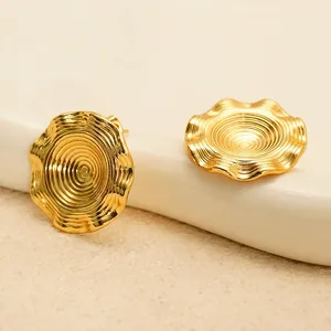Elegant 18k gold plated stainless steel textured disc earrings on ceramic tray