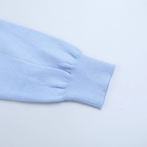 Gros plan détaillé du poignet de cardigan bleu clair avec texture tricotée fine
