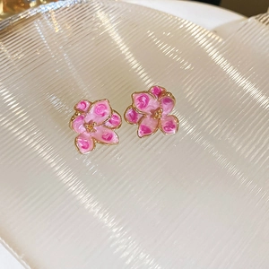 Close-up of pink oil-dripped flower earrings with golden edges and metal stamen details