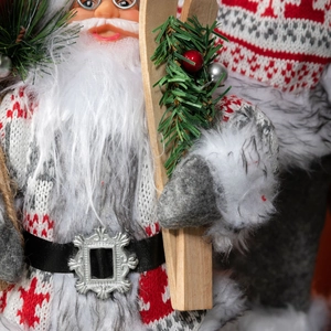 Charming Santa Claus figurine in red and grey knitting with wooden skis and fur trim