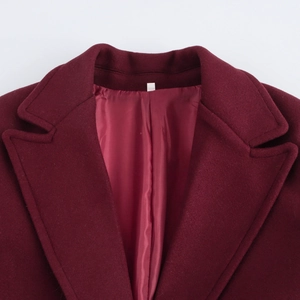 Macro detail of wine red wool coat featuring precise collar stitching and satin lining