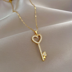 Detail view of heart key pendant with sparkling rhinestones on gold titanium necklace