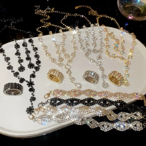 Close-up of sparkling rhinestone pavé jewelry set featuring a gold necklace and ring