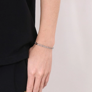 Detail shot of a flat 3:1 link stainless steel bracelet worn on a wrist for men