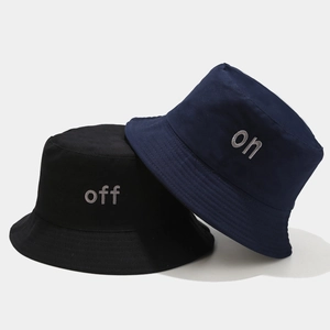 Détail des lettres brodées ON et OFF sur chapeaux bob en coton noir et bleu marine