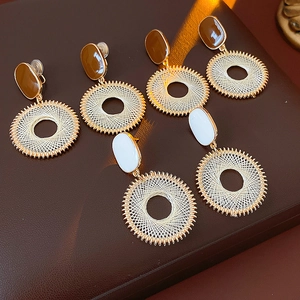 Detailed macro view of woven grid pattern earrings in brown and white resin finishes