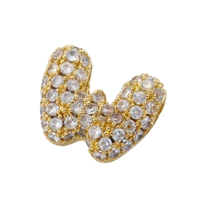 Macro detail of gold-plated letter W pendant encrusted with sparkling cubic zirconia