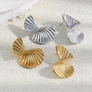 Detailed view of twisted fan-shaped metal studs in gold and silver finish on stone
